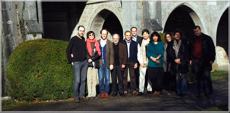 The twelve participants of the 2014 general assembly, standing together outside a stone cloister in Belgium.